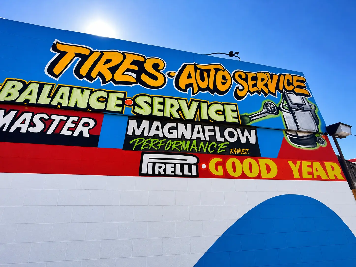 Hand-painted tires and auto service mural at the shop