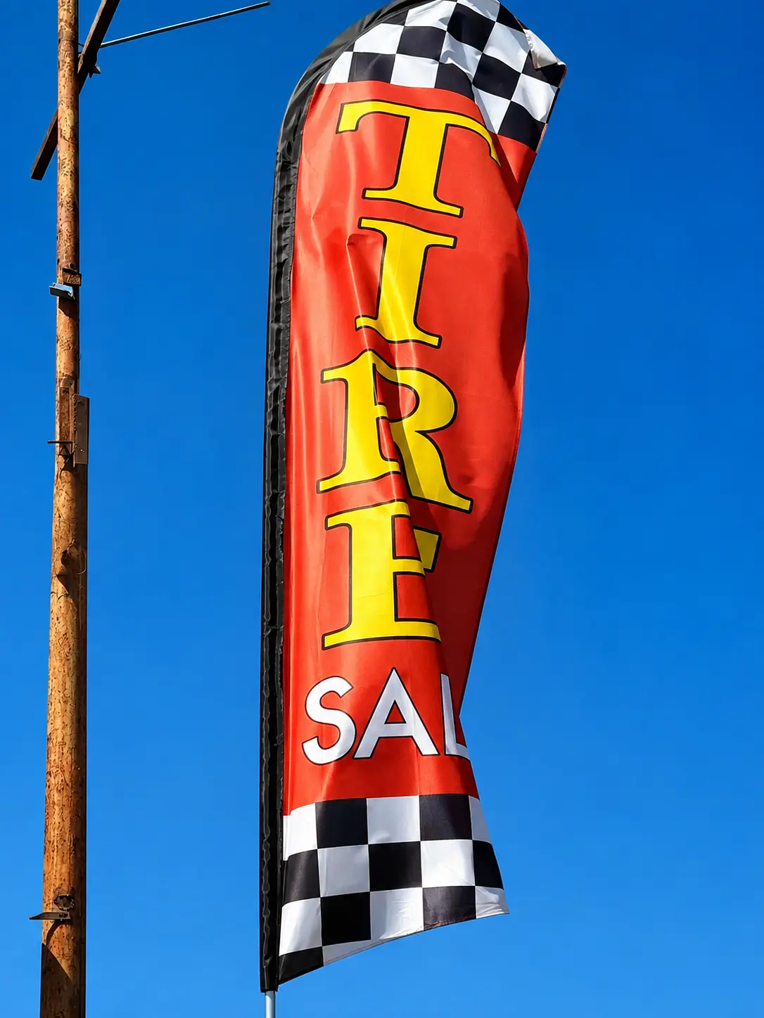 Tire sale feather flag flying outside the shop